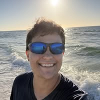 Jamie smiling by the water